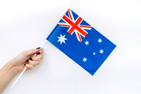 Symbol of the national day of Australia concept with flag in hand on white background top viewの写真素材