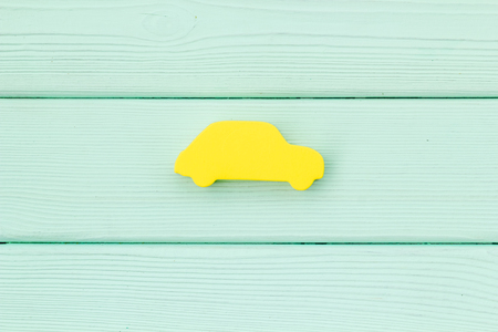 Car buying and insurance concept with car figure on mint green wooden desk background top view mockupの写真素材