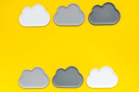 Cloud computing concept with clouds on yellow work desk background top view space for textの写真素材