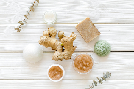 Body treatment. Cosmetics with natural herbal and ginger ingredients on white wooden background top viewの写真素材