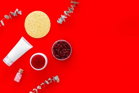 Scrubs and creams for natural cosmetic set with herbs and grapefruit on red background top view mock upの写真素材