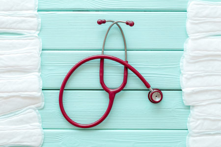 Female health and medicine. Gynaecologist and woman health concept with stethoscope and tampons on mint green wooden background top viewの写真素材