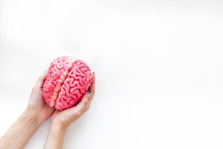 Mental specialist desk. Mental health. Disease of the brain concept with brain in hands on white background top viewの写真素材