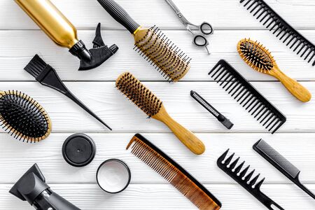 Hair cut concept. Professional accessories of hairdresser with combs and scissors on work desk wooden white background top view patternの写真素材