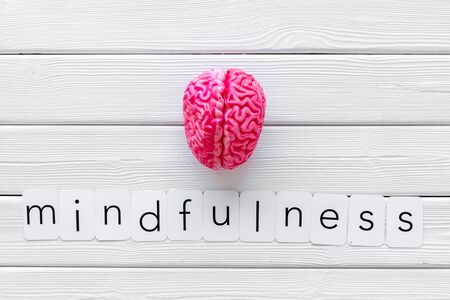 Mental health. Mindfulness and meditation concept with brain on white wooden background top viewの写真素材