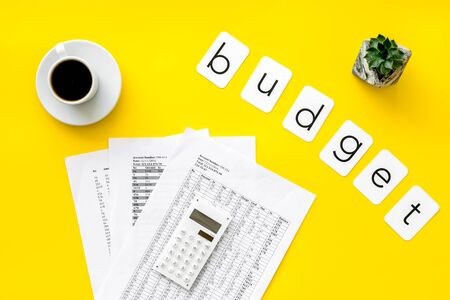 Business budget. Budget plan with calculator, coffee and plant on yellow background top viewの写真素材