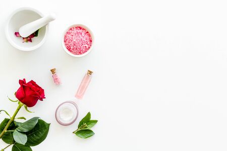 Body care and treatment. Cream, bath salt, lotion for organic cosmetics with rose flower on white background top view space for textの写真素材