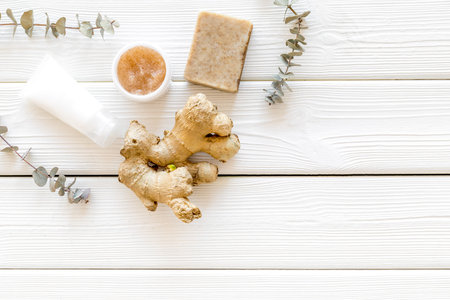 Organic set for spa. Natural herbal cosmetics with ginger on white wooden background top view space for textの写真素材
