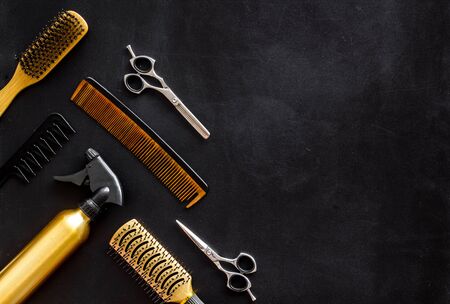 Hair styling concept. Combs and hairdresser tools on beauty salon work desk on black background top view mockupの写真素材