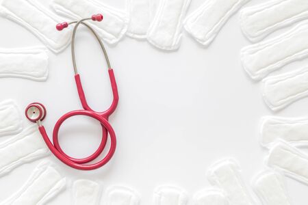 Menstrual period. Gynaecologist and woman health concept with stethoscope and sanitary pads on white background top viewの写真素材