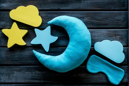 Sleep time concept with moon, stars, clouds, blindfolder on wooden background top viewの写真素材
