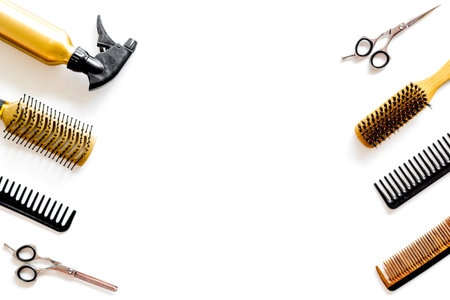 Hair styling concept. Combs, spray and hairdresser tools on beauty salon work desk on white...