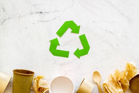 Eco friendly. Recycling sign with waste materials, paper cup, tableware for ecology save concept on marble background top view mock upの写真素材