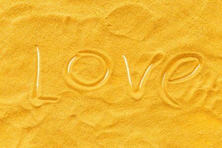 Blog or presentation background with yellow sand texture and love text top view.の写真素材
