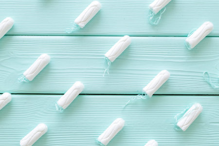 Woman health. Gynaecologist and menstruation concept with tampons pattern on mint green wooden...