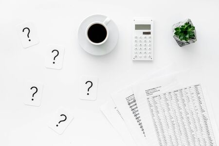 Business and accountant concept with coffee, budget, question mark and calculator on white office work desk background top viewの写真素材