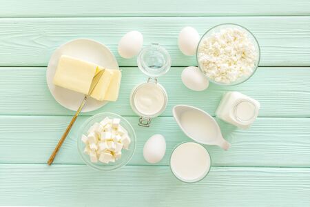 Farm products. Fresh dairy products for breakfast with milk, cottage, eggs, yogurt on mint green wooden background top viewの写真素材