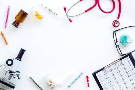 Laboratory. Medical tests on work table of doctor with microscope, cardiogram, pills, test tube on white background top view copyspaceの写真素材