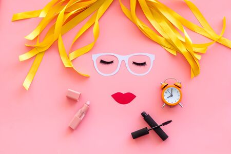 make up concept with face model for visagiste work and alarm clock on pink background top viewの写真素材