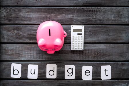 Business and budget concept with piggy bank and calculator on wooden office work desk background top viewの写真素材