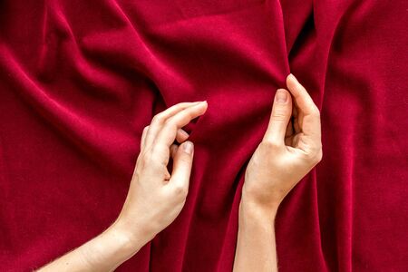 Abstract red fabric texture pattern and hands top viewの写真素材