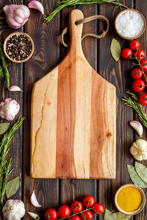 Ingedients frame, cutting board and cookware for cooking on wooden background top view copy spaceの写真素材