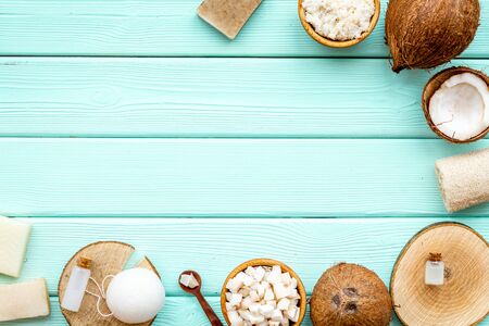 Face, body and hair treatment. Organic cosmetics with coconut oil, soap, bath puff on mint green wooden background top view mockupの写真素材