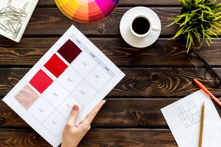 Illustrator instruments. Designer work space with pallet in hands, glasses and cup of coffee on wooden background top viewの写真素材