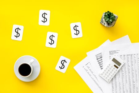 Budget plan with calculator, coffee and dollar sign on yellow background top view.の写真素材