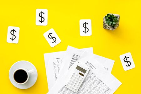 Budget plan with calculator, coffee and dollar sign on yellow background top view.の写真素材
