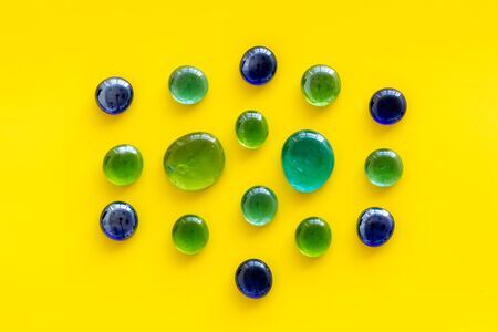 Shiny glass stones for decoration, creativity and craft on yellow background top viewの写真素材