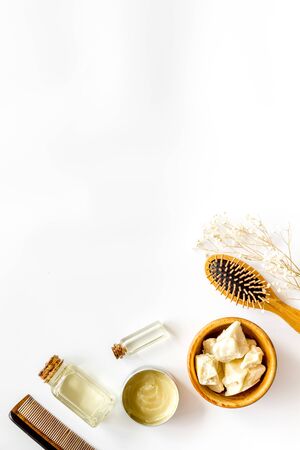 Bottle with jojoba, argan or coconut oil, styling, comb for hair style on white background top view mock upの写真素材