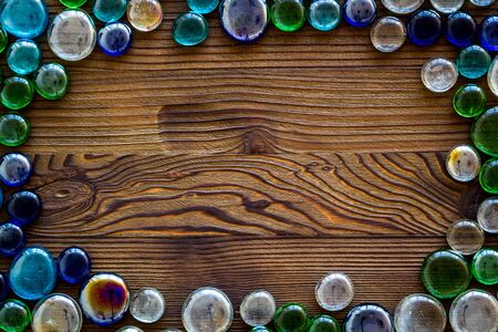 Shiny glass stones for decoration, creativity and craft on wooden background top view copyspaceの写真素材