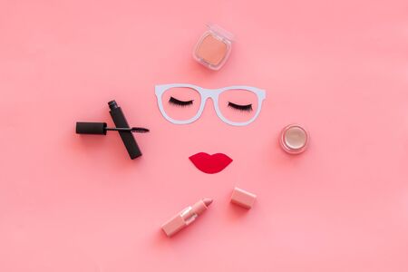 Decorative cosmetic. Make up concept with face model, lipstick, mascara, blusher for visagiste work on pink background top viewの写真素材