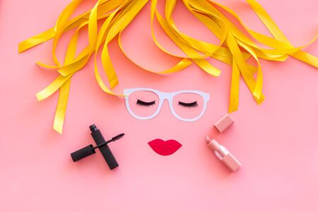 Decorative cosmetic. Visagiste work space with face model, mascara and lipstick on pink background top viewの写真素材