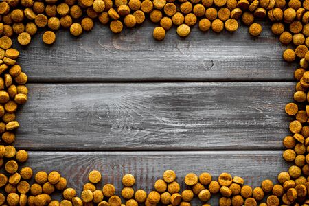 Puppy and kitten care. Dry pet food frame on wooden background top view space for textの写真素材
