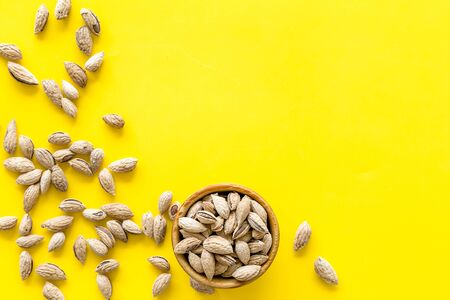 Healthy snack. Almond in bowls for cooking on yellow background top view mockupの写真素材