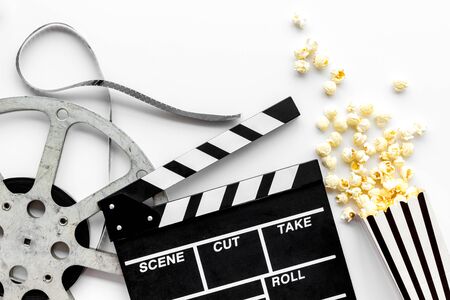 Movie premiere concept. Watch film in cinema with popcorn, video tape and clapperboard on white background top viewの写真素材