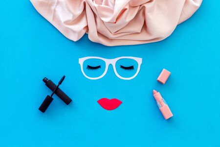 Decorative cosmetic for make up with face model on blue background top viewの写真素材
