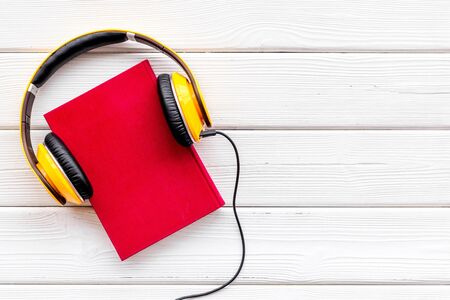 Listen to audio books with headphone on white wooden library desk background flatlay mock upの写真素材