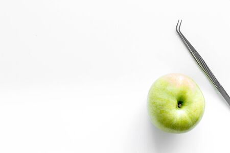 Teeth care and oral health. Dentist desk with instruments and apple on white background top view mock-upの写真素材