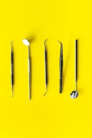 Teeth care and oral health. Dentist desk with instruments on yellow background top view mockupの写真素材