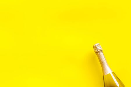 Alcohol for party. Champagne bottle for celebration on yellow background top view mock upの写真素材