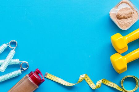 Protein powder for fitness nutrition, bars, measuring tape to start training on blue background top view mock upの写真素材