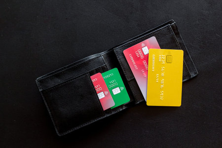 Pay by card in online shop concept and wallet on black background top viewの写真素材