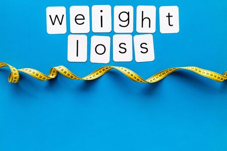 Measuring tape and weight loss concept for sport concept on blue background top view space for textの写真素材