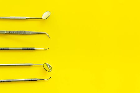 dentist desk with instruments on yellow background top view mockupの写真素材