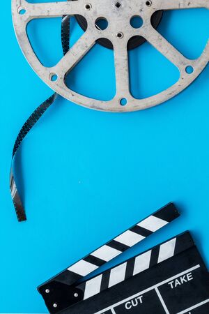 Go to the cinema with film type and clapperboard on blue background top view mock upの写真素材