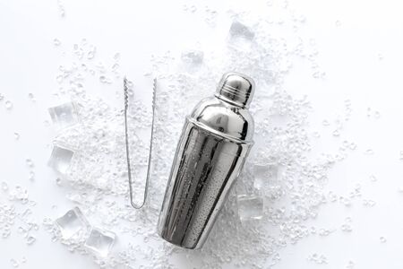 ice cubes and shaker on white table top view