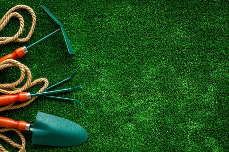 Instruments for gardener on green grass background top view mockupの写真素材